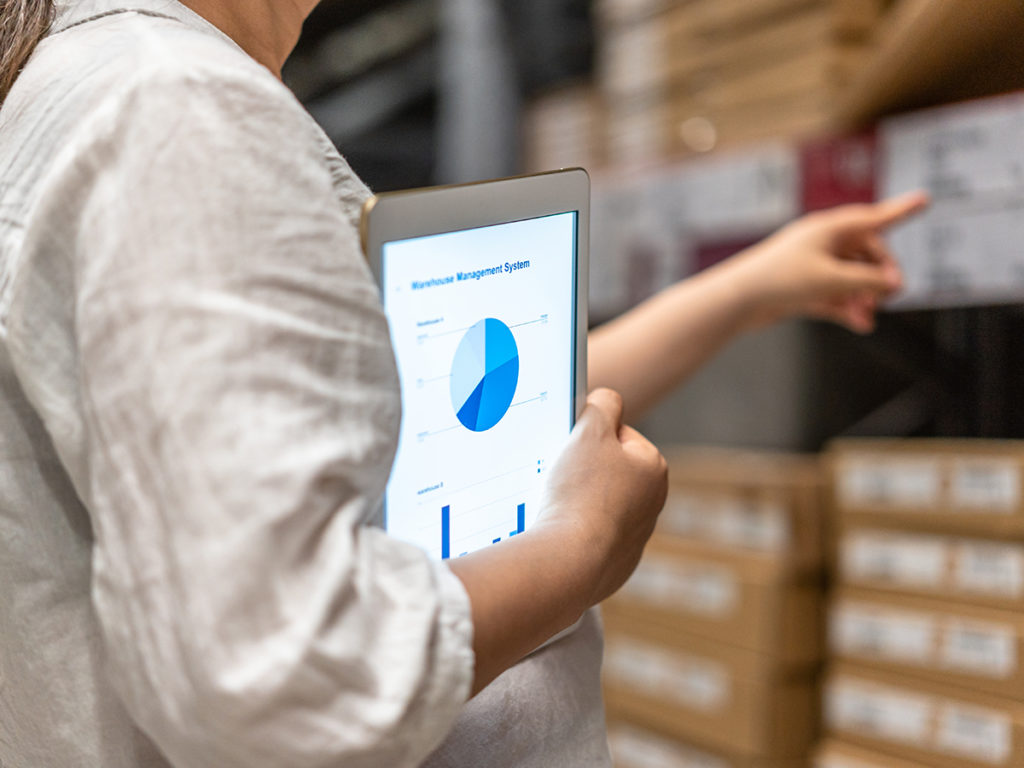 man holding tablet with pie chart in warehouse