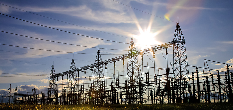 Sun setting over an electrical substation.