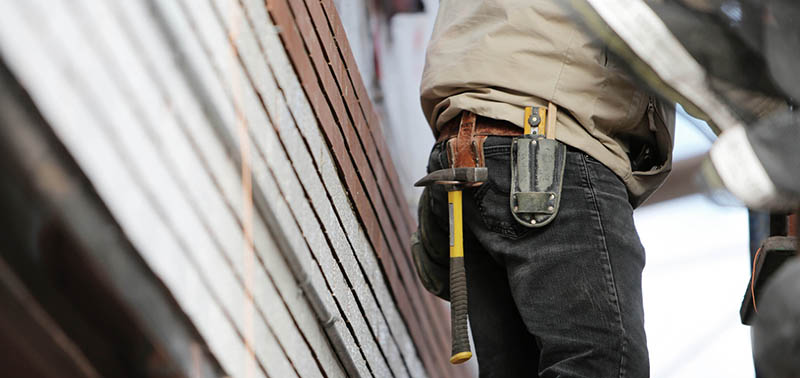 Man Wearing Black Denim Pants With Carrying Hammer on Holster