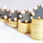 stacks of gold coins with people-shaped silver figures on top