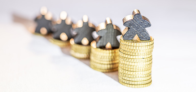 stacks of gold coins with people-shaped silver figures on top