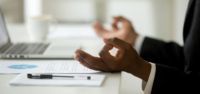 African american calm businessman relaxing meditating in office, peaceful ceo in suit practicing yoga at work, focus on black man hands in mudra, successful mindful people habits concept, close up