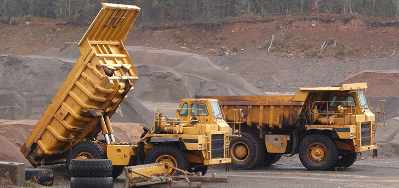 Off-Highway trucks parked in gravel pit.