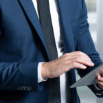 Businessman wearing suit and tie using his tablet