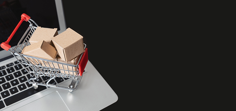 e-commerce, shopping trolley with paper boxes. Trade, selling via internet