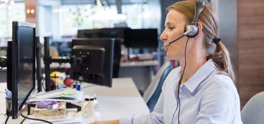 female customer support phone operator with headset  at workplace