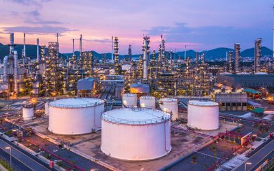 Aerial top view oil and gas chemical tank with oil refinery plant background at twilight.