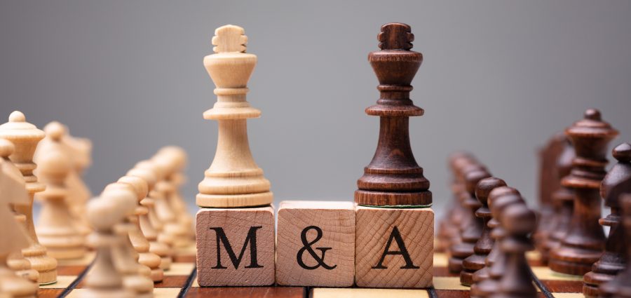 Close-up Of King Chess Pieces On Wooden Blocks With Mergers And Acquisitions