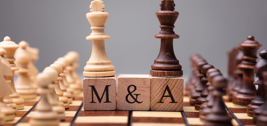 Close-up Of King Chess Pieces On Wooden Blocks With Mergers And Acquisitions