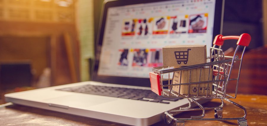 Shopping online concept - Parcel or Paper cartons with a shopping cart logo in a trolley on a laptop keyboard. Shopping service on The online web. offers home delivery.