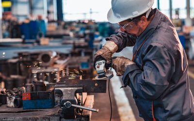 Skilled industrial worker grinding metal part.