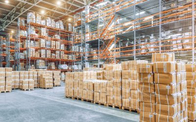 Large industrial warehouse with high racks. In the foreground are a lot of cardboard boxes. Overloaded warehouse building.