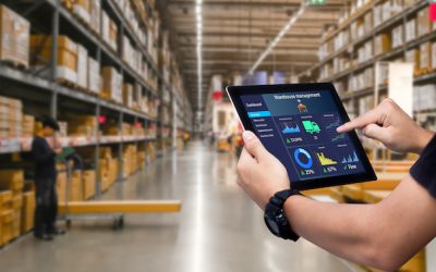 Smart warehouse management system.Worker hands holding tablet on blurred warehouse as background