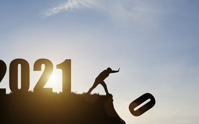 Man push number zero down the cliff where has the number 2021 with blue sky and sunrise. It is symbol of starting and welcome happy new year 2021.