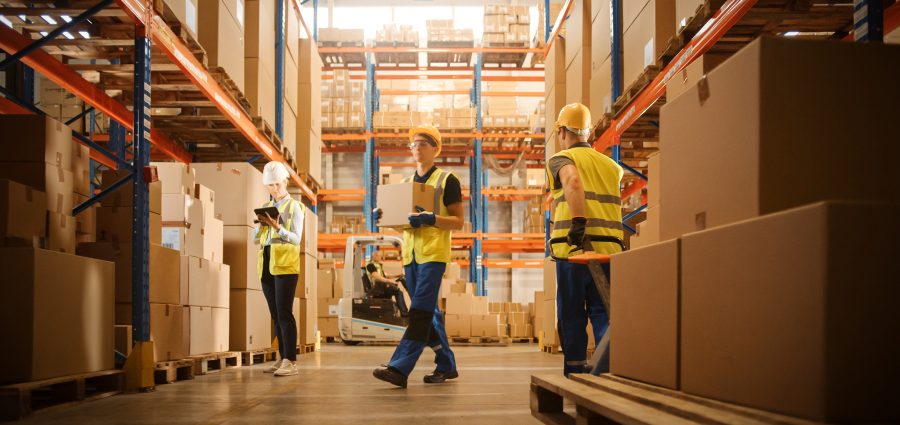 Retail Warehouse full of Shelves with Goods in Cardboard Boxes, Workers Scan and Sort Packages, Move Inventory with Pallet Trucks and Forklifts. Product Distribution Logistics Center.