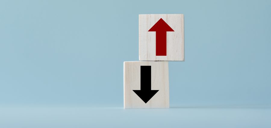 Up and down turn arrow on wooden blocks difference direction to earn or to loss