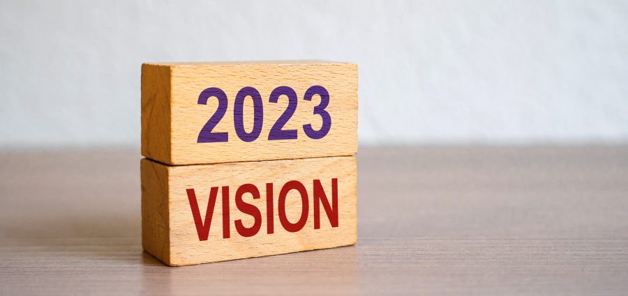 Hand puts blocks with the words 2023 Vision. Concept for business ideas and goals. Strategy development. Planning and action plan. Performance, motivation and company management.