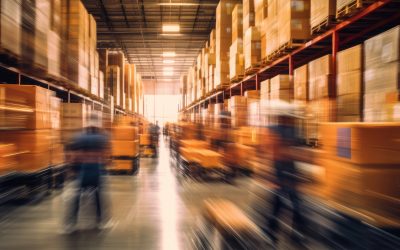 Blurred image of warehouse employees moving shipping boxes