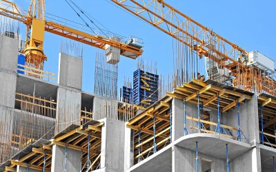 Crane and building construction site against blue sky