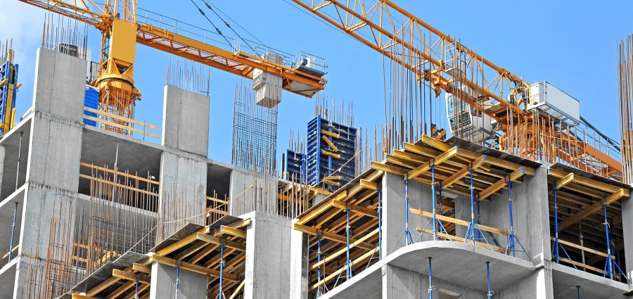 Crane and building construction site against blue sky