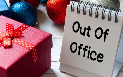 Out of office text on notepad with Christmas decoration. Holiday concept.