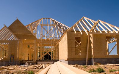 A new home being built with wood, trusses, supports and a foundation.