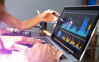 office workers analyzing graph on laptop