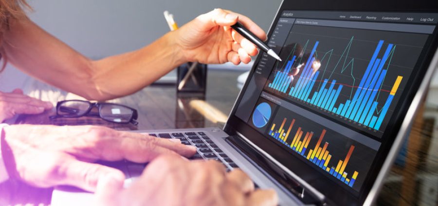 office workers analyzing graph on laptop