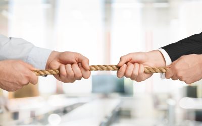 Business people pulling rope in opposite directions at office