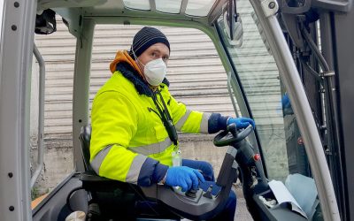 coronavirus : man with protective mask and gloves drives the forklift