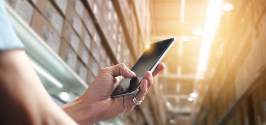 Person in warehouse using cellphone to automate processes