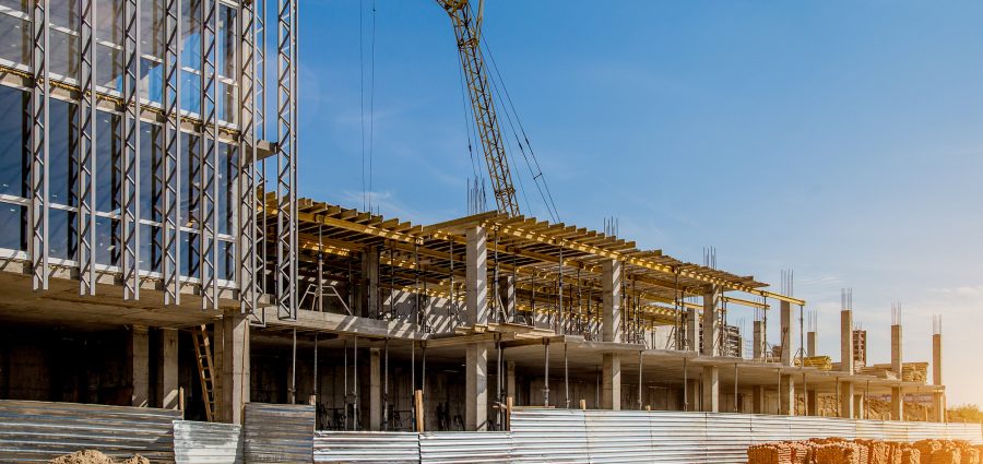 Construction site background. Hoisting cranes and new multi-storey buildings. I.ndustrial background.Building construction site work against blue sky