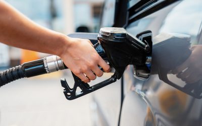 Closeup of woman pumping gasoline fuel in car at gas station. Petrol or gasoline being pumped into a motor. Transport concept