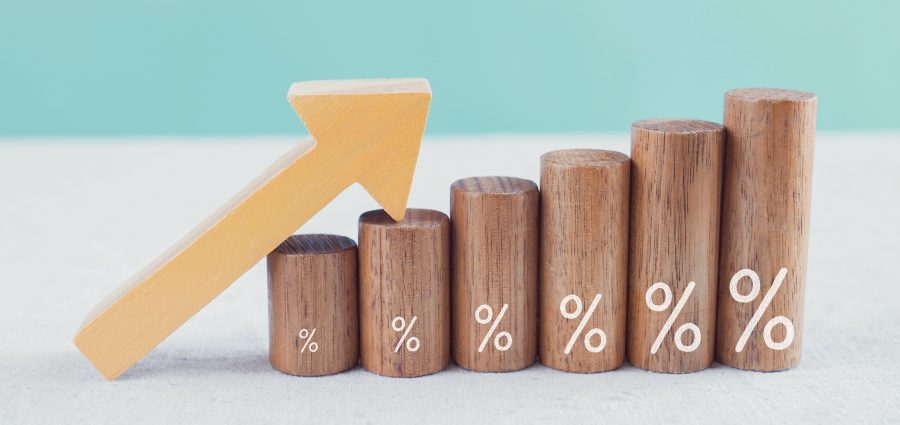 Wooden blocks with percentage sign and arrow up, financial growt