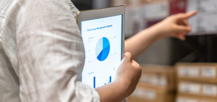 man holding tablet with pie chart in warehouse