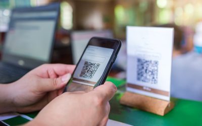 Closeup of a hand holding phone and scanning QR code with blurry