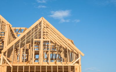 Close-up of gables roof on stick built home under construction and blue sky in Humble, Texas, USA. New build roof with wooden truss, post and beam framework. Timber frame house, real estate. Panorama