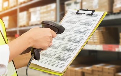 Worker checking and scanning package by laser barcode scanner in modern warehouse.