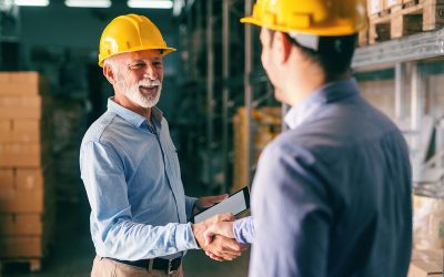 Two businessmen shaking hands for successful business while stan