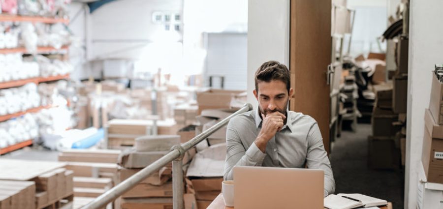 Manager working online while sitting in a warehouse office