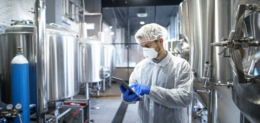 man in lab working with tablet and chemicals