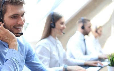 Portrait of call center worker accompanied by his team. Smiling customer support operator at work