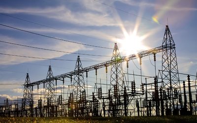 Sun setting over an electrical substation.