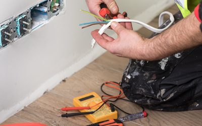 electrician separating wiring next to white wall