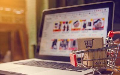 Shopping online concept - Parcel or Paper cartons with a shopping cart logo in a trolley on a laptop keyboard. Shopping service on The online web. offers home delivery.