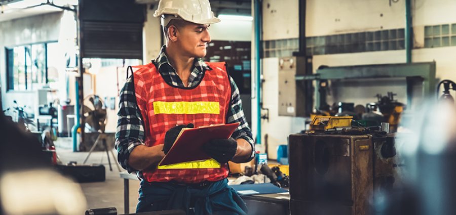 Manufacturing worker working with clipboard to do job procedure checklist .