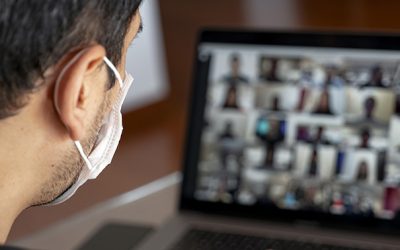 Man using a mask and having a video conference with work team am